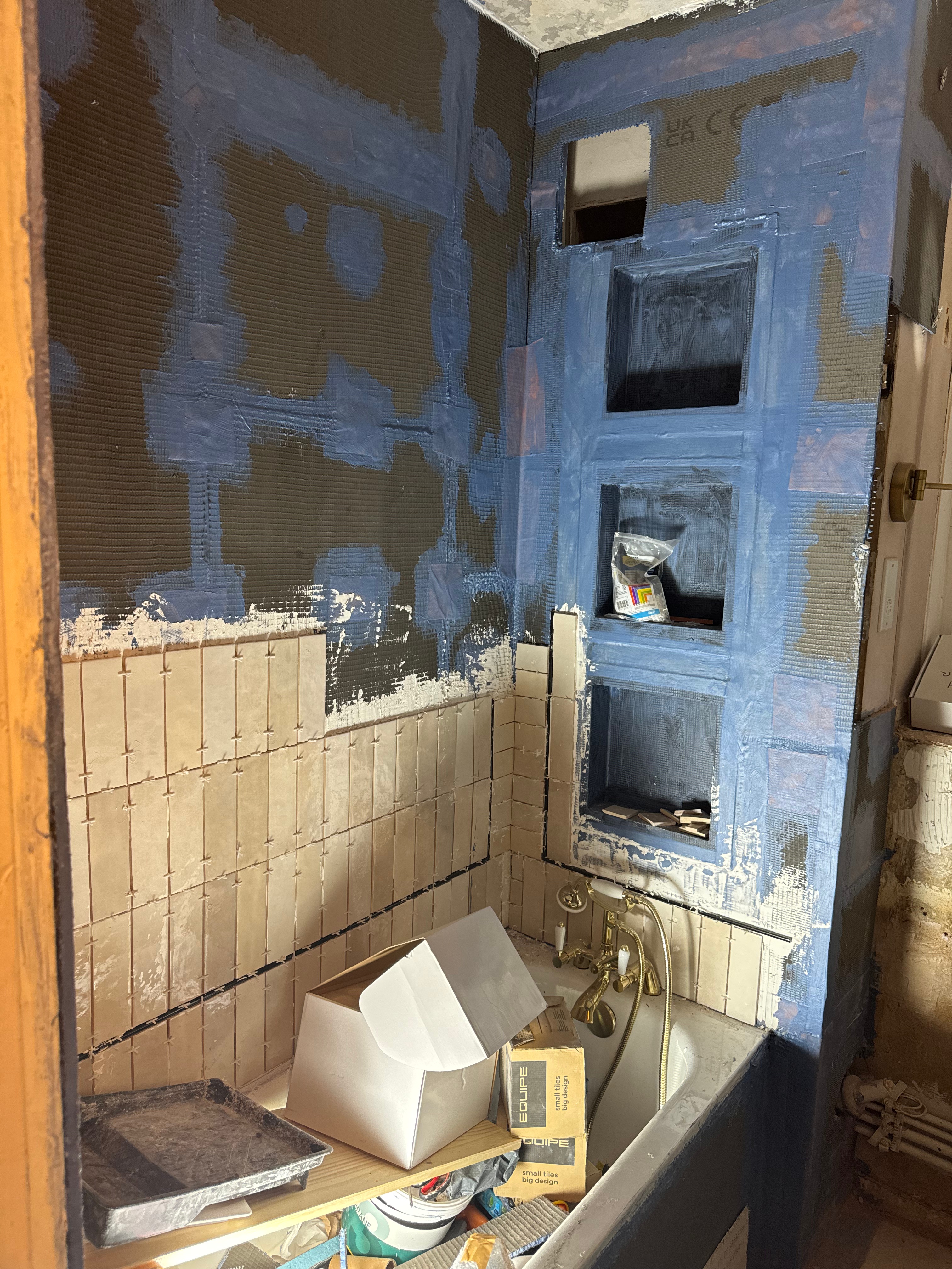 unfinished bathroom tiling project with a shower niche