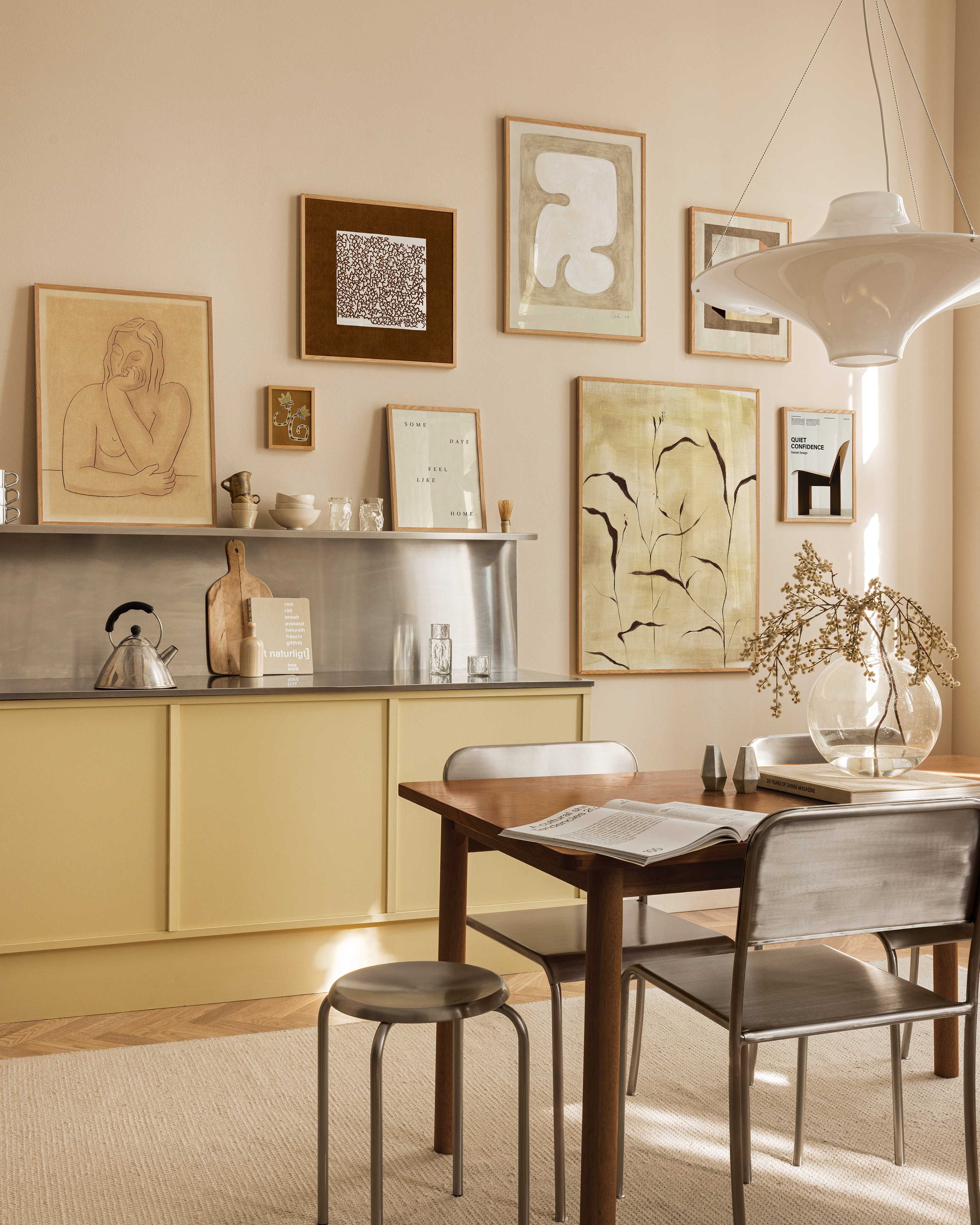butter yellow kitchen cabinets and art frames on wall