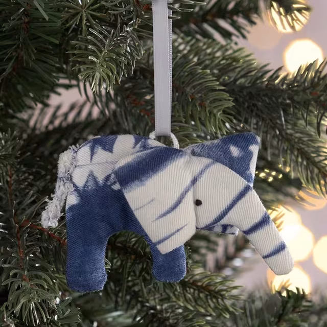 a grey and white tie dyed elephant  tree ornament hanging on a christmas tree