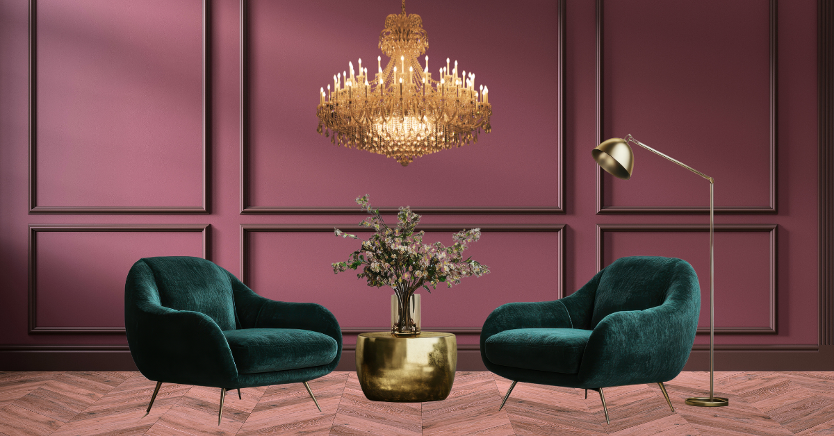 forest green armchairs against a burgundy wall with wood panels. A brass chandelier hangs above and a brass floor lamp sits to the right.